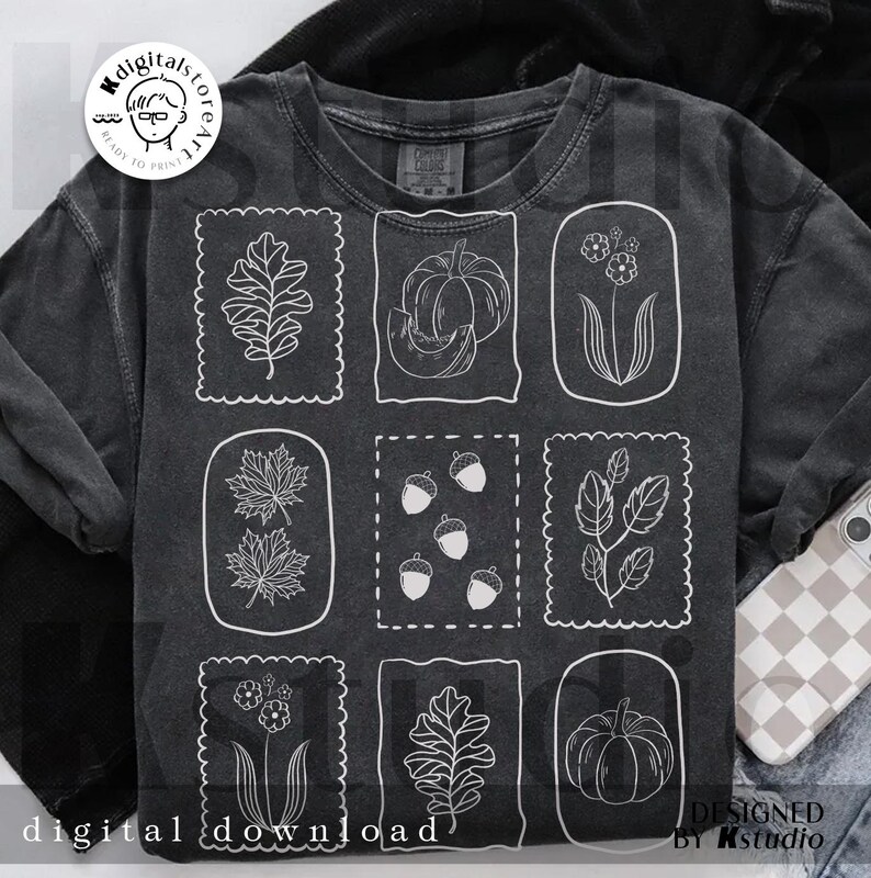 May include: Dark gray sweatshirt featuring nine white line drawings of fall-themed elements, including leaves, pumpkins, acorns, and flowers. The words "digital download" are printed at the bottom. The design is by kstudio.