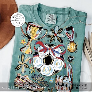 K&ouml;nnte beinhalten: Ein teal Comfort Colors T-Shirt mit Fu&szlig;ballmotiven. Das Design umfasst einen Fu&szlig;ball mit roter Schleife, eine Troph&auml;e, eine Goldmedaille, einen Fu&szlig;ballschuh und eine Handgeste mit der Nummer eins. Unten steht "digital download".