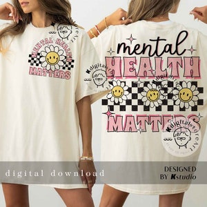 May include: A white t-shirt with a pink and black graphic design that says "mental health matters". The graphic features a checkered pattern, daisies, and smiley faces.