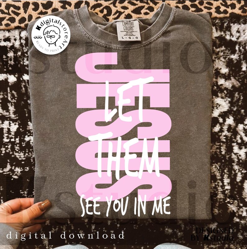 May include: A gray t-shirt with the words "JESUS LET THEM SEE YOU IN ME" in pink and white. The shirt is a digital download and features a Comfort Colors label.