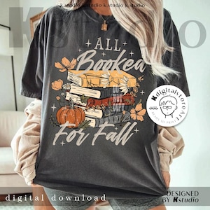 May include: Dark gray t-shirt with the text "ALL Booked For Fall" above a stack of books, a pumpkin, and floral accents. The design is in shades of orange, yellow, and white. The words "digital download" and "designed by Kstudio" are also visible.