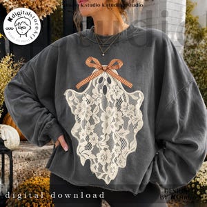 May include: A charcoal gray crewneck sweatshirt featuring a large, off-white lace ghost graphic on the front. The ghost design is adorned with a small, orange and white checkered gingham bow at the top, creating a textured, layered appearance.