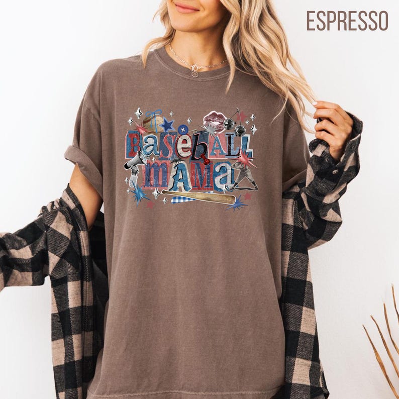 K&ouml;nnte beinhalten: Espressofarbenes T-Shirt mit dem Text "Baseball Mama" in einer Collage von Baseball-Grafiken. Das Design umfasst Sterne, einen Baseballschl&auml;ger und einen Baseball. Das Shirt hat kurze &Auml;rmel und eine lockere Passform.
