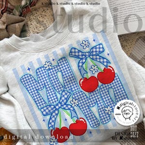 May include: A light gray sweatshirt with a graphic design featuring the word "MOM" in blue gingham print, adorned with red cherries and blue bows. The design includes white flowers and blue stripes. The words "digital download" are at the bottom.