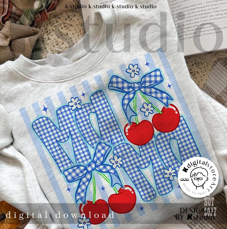 May include: A light gray sweatshirt with a graphic design featuring the word "MOM" in blue gingham print, adorned with red cherries and blue bows. The design includes white flowers and blue stripes. The words "digital download" are at the bottom.