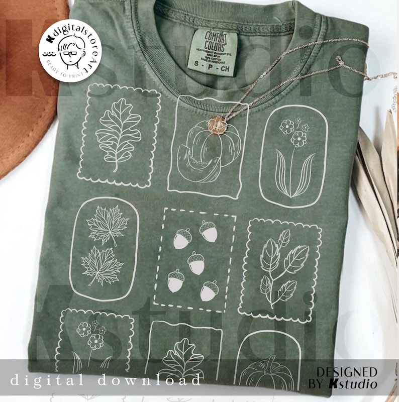 May include: Green t-shirt with white line art illustrations of fall elements, including leaves, acorns, and pumpkins. The shirt has a crew neck and short sleeves. The text "digital download" is at the bottom.