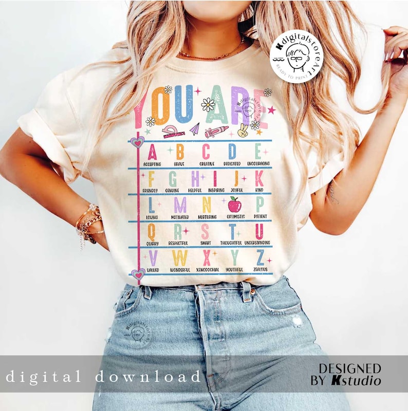 May include: A white t-shirt with a colorful alphabet chart that says "You Are" at the top. Each letter of the alphabet is paired with a positive adjective. For example, "A" is for "Accepting" and "B" is for "Brave".