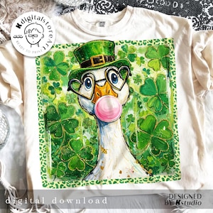 May include: A cream-coloured t-shirt with a St. Patrick's Day design. It features a goose wearing a green hat and heart-shaped glasses, blowing a pink bubble. The design includes shamrocks and a leopard print border. The text "digital download" is also visible.