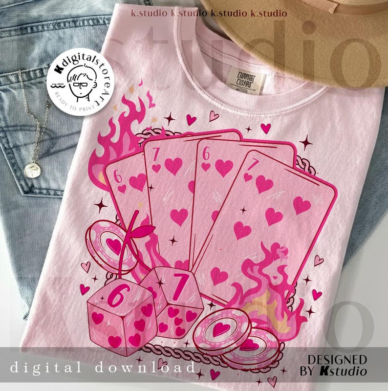 May include: A light pink t-shirt featuring a graphic design of playing cards, dice, and poker chips with heart symbols. The design includes the numbers six and seven, flames, and the text "digital download" and "designed by kstudio".