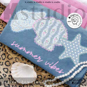 May include: A denim blue fabric with seashell, cloud, and starfish designs, embellished with lace and pearls. The text "summer vibes" is in pink. A seashell and a pearl necklace are also visible.