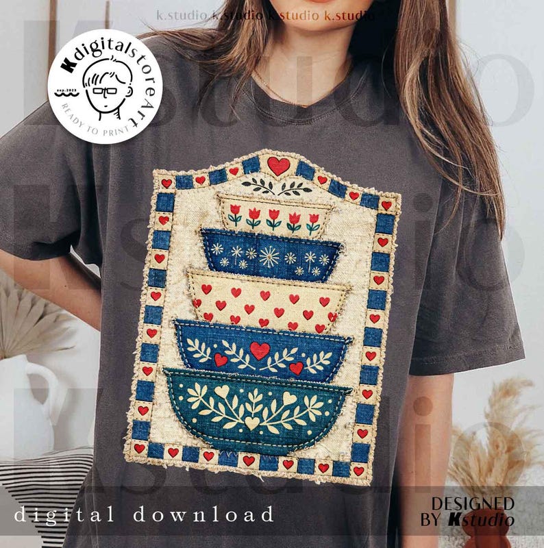 Pu&ograve; includere: T-shirt grigio scuro con una grafica di ciotole impilate decorate con cuori e fiori. Le ciotole sono blu e crema, con un bordo blu e rosso. Il testo "digital download" &egrave; nella parte inferiore del design.