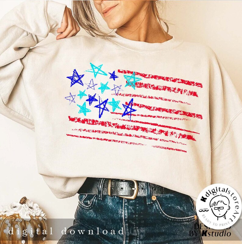 May include: A white sweatshirt with a red, white, and blue American flag design. The flag is made up of red and white stripes with blue stars in the top left corner. The stars are drawn in a childlike style.