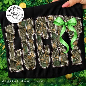 May include: Black t-shirt with the word "LUCKY" in large, bold letters. The letters are filled with a camouflage pattern and outlined in white. A green bow is attached to the right side of the word. The words "digital download" are at the bottom.