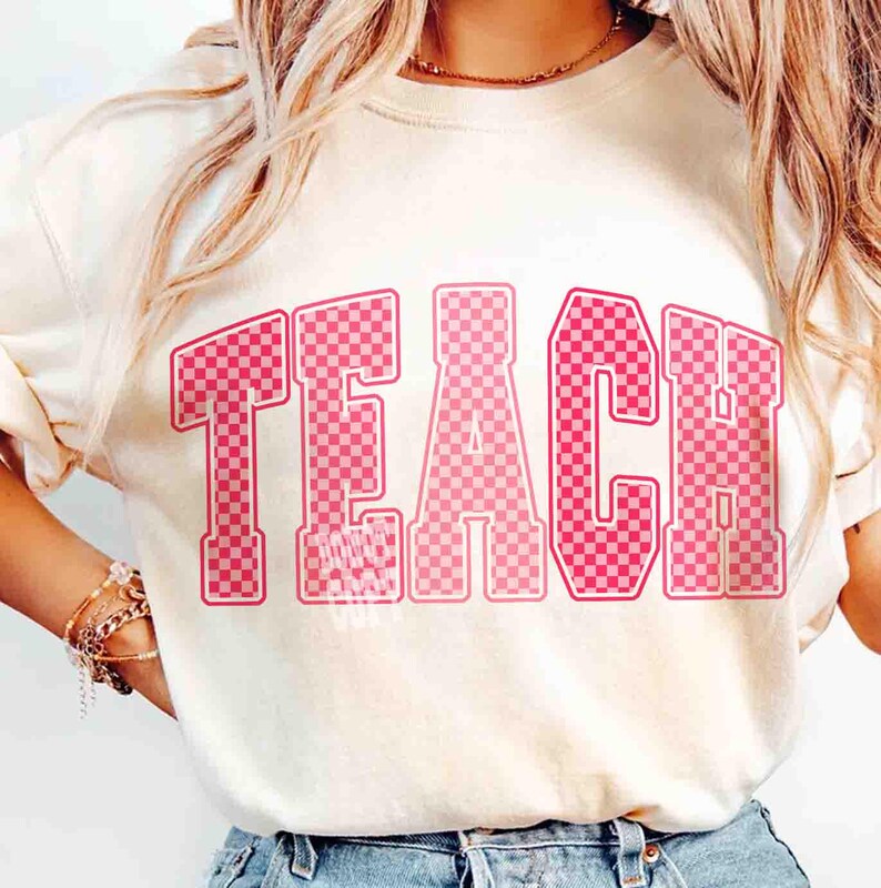 K&ouml;nnte beinhalten: Cremefarbenes Sweatshirt mit dem Wort "TEACH" in gro&szlig;en, rosa karierten Buchstaben auf der Vorderseite. Die Buchstaben haben einen Retro-College-Stil. Das Shirt ist ein l&auml;ssiges Kleidungsst&uuml;ck f&uuml;r den Alltag.