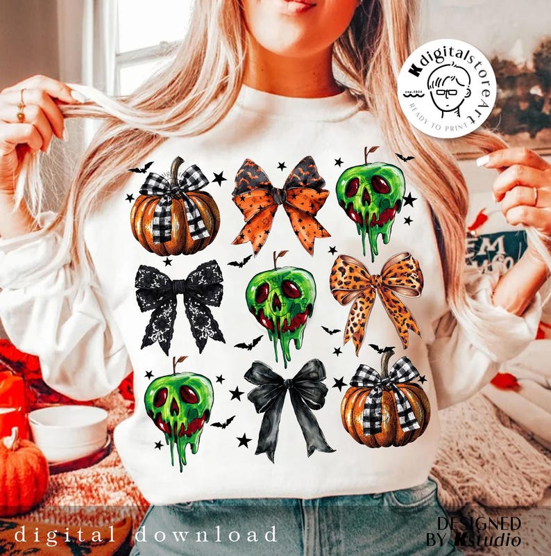 May include: White sweatshirt featuring Halloween-themed graphics. The design includes pumpkins, bows, and green apple skulls with dripping red accents. Black bats and stars are scattered around the images. The words "digital download" are printed at the bottom.