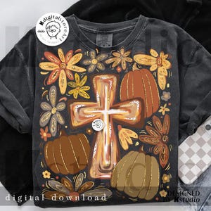May include: Dark gray sweatshirt with a fall-themed design. The design includes a cross, pumpkins, and flowers in shades of brown, orange, and gold. The words "digital download" are at the bottom.
