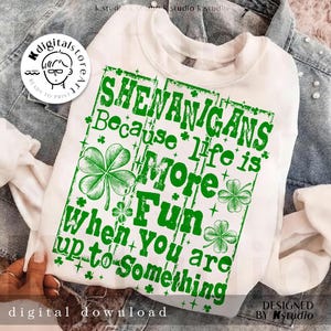 Op de afbeelding: Witte sweatshirt met een groene opdruk met de tekst "SHENANIGANS Because life is More Fun When you are up to Something." Het ontwerp bevat klavers en sterren. De woorden "digital download" staan onderaan.