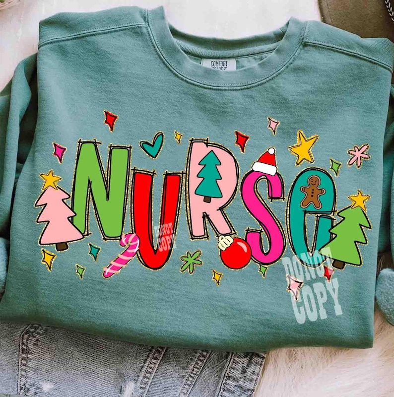 May include: A teal-colored sweatshirt with the word "NURSE" in colorful, festive lettering. The letters are decorated with Christmas-themed graphics, including a Christmas tree, ornaments, and a gingerbread man. The sweatshirt has a crew neck.