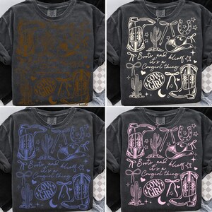 May include: A dark gray long-sleeve shirt with a distressed graphic design. The design includes cowboy boots, a cowboy hat, a horseshoe, and the text "Boots and bling it's a Cowgirl thing". The shirt also features a cactus and stars.