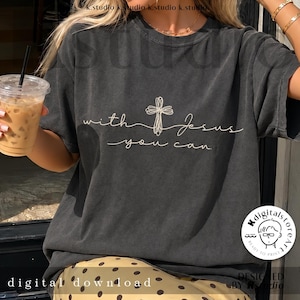 Op de afbeelding: Een antracietgrijs T-shirt met korte mouwen, voorzien van een witte lijntekening van een kruis en de tekst "with Jesus you can". Het shirt heeft een ronde hals en een relaxte pasvorm, met het ontwerp gecentreerd op de borst in een cursief lettertype.