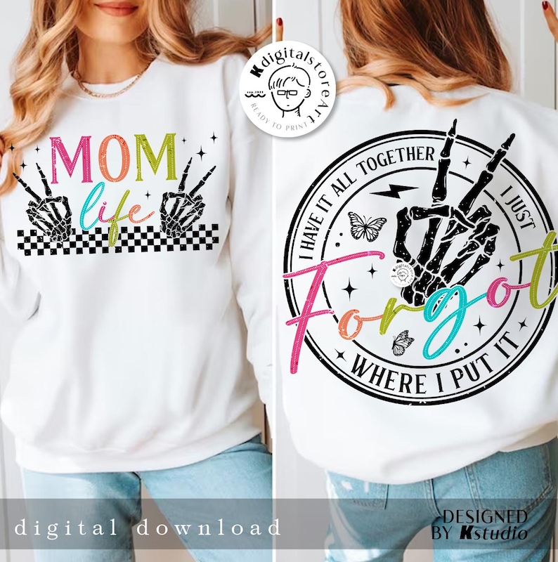May include: White sweatshirt with a black and white checkered design and the text "MOM life" in rainbow colors. The back of the sweatshirt has a black and white circle with the text "I have it all together I just forgot where I put it" in rainbow colors.