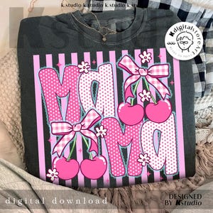 Op de afbeelding: Donkergrijze sweatshirt met een roze en witte afbeelding met de tekst "Mama". Het woord "Mama" is ontworpen met roze stippen en ruitpatronen, met kersen en strikken. De woorden "digitale download" en "ontworpen door kstudio" zijn ook zichtbaar.