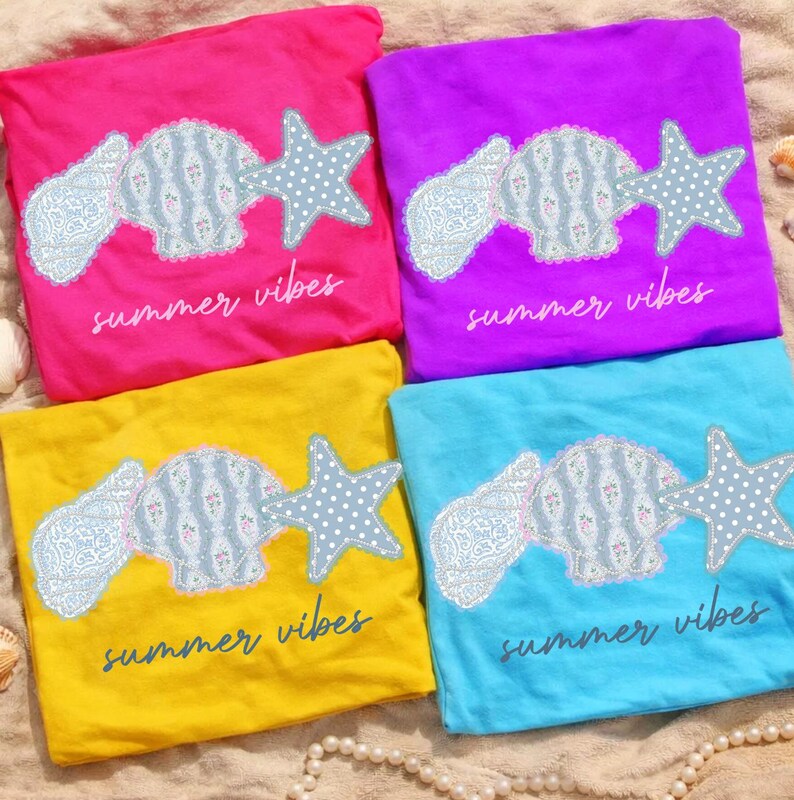 May include: Four colorful t-shirts: pink, purple, yellow, and blue. Each shirt features a seashell and starfish design with the text "summer vibes". The seashell and starfish are light blue with a white polka dot pattern.