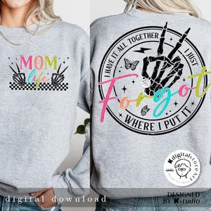 May include: A gray sweatshirt with two designs. The front design says "MOM life" with a checkered pattern and two skeleton hands with peace signs. The back design is a circle with the text "I have it all together I just forgot where I put it" with a skeleton hand with a peace sign, a butterfly, and lightning bolt.