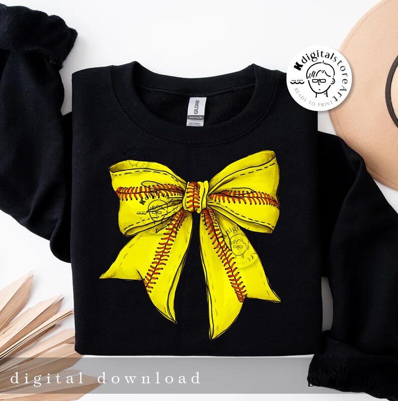 Puede incluir: Sudadera negra con un dise&ntilde;o de lazo de softball amarillo. El lazo est&aacute; hecho de dos cintas amarillas con costuras rojas, que se asemejan a una pelota de softball.