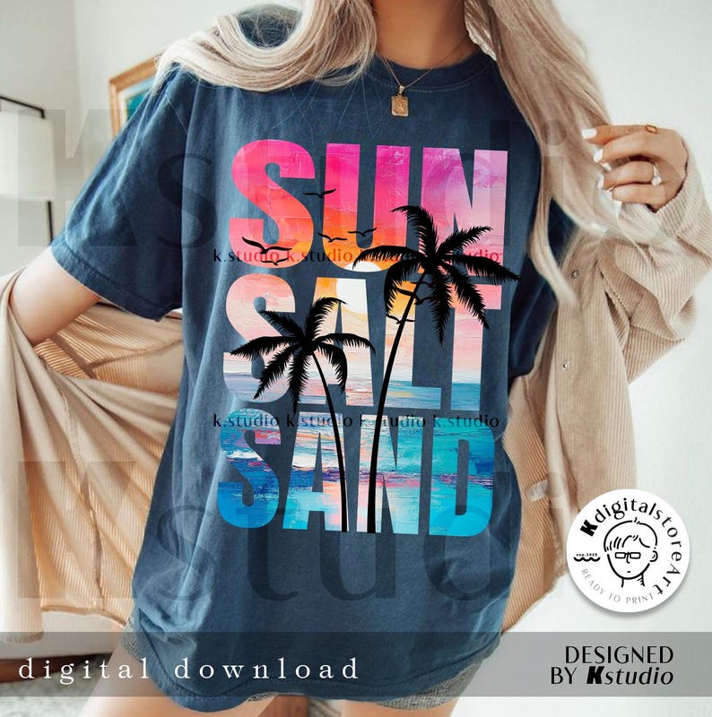 May include: A dark blue t-shirt with a colorful graphic design that says "SUN SALT SAND" with palm trees and a sunset background.