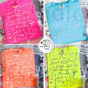 May include: Four brightly colored t-shirts: pink, blue, orange, and yellow. Each shirt features a graphic design with a cross, a Bible, doves, and the text "With God All things are Possible".