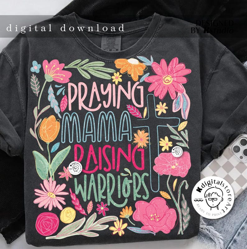 May include: A black t-shirt with a floral design and the text "Praying Mama Raising Warriors".