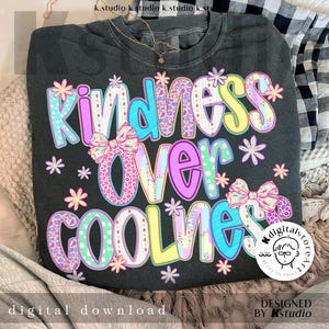 May include: Dark gray sweatshirt with the words "Kindness Over Coolness" in colorful, patterned letters. The design includes bows and floral accents. The phrase "digital download" is at the bottom.