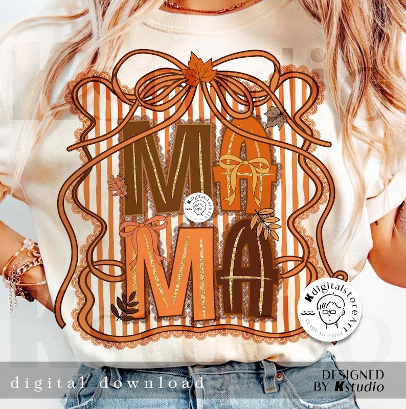 Op de afbeelding: Cr&egrave;mekleurig T-shirt met het woord "MAMA" in bruine en oranje blokletters, versierd met herfstaccenten. Het ontwerp bevat een strik, bladeren en een gestreepte achtergrond. De woorden "digital download" en "designed by Kstudio" zijn ook zichtbaar.