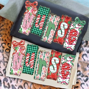 May include: Two t-shirts, one black and one cream, with the word "MERRY" in a festive design. Each letter is a different pattern, including plaid, candy canes, and polka dots. The design is topped with a bow.