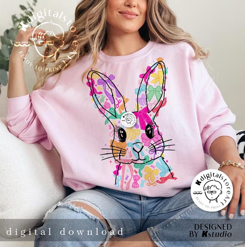 May include: A pink sweatshirt with a colorful bunny rabbit design made of bows. The bunny is looking directly at the viewer. The text "digitals to create" is on the bottom right corner of the image.