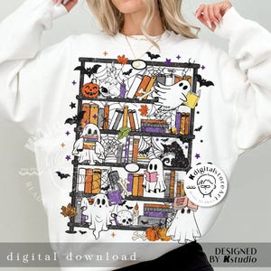May include: White sweatshirt featuring a Halloween-themed bookshelf design. The graphic includes ghosts, pumpkins, books, bats, and spiderwebs. The words "digital download" are printed at the bottom of the sweatshirt.