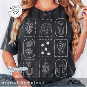 May include: Dark gray t-shirt featuring nine white line drawings of fall-themed elements, including leaves, pumpkins, acorns, and flowers, within decorative frames. The words "digital download" are at the bottom. The design is by Kstudio.