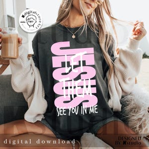 May include: Dark gray t-shirt with the text "JESUS LET THEM SEE YOU IN ME" in pink. The shirt is a digital download. The design is by Kstudio.