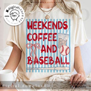 May include: Cream-colored t-shirt with a graphic design featuring the words "WEEKENDS COFFEE AND BASEBALL" in red. The design includes a baseball, a bow, a coffee drink, and a baseball bat against a blue and white striped background.