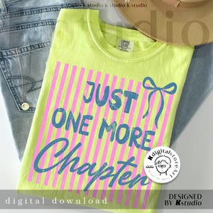 Puede incluir: Una camiseta verde ne&oacute;n con el texto azul "JUST ONE MORE Chapter" sobre rayas verticales rosas. La camiseta est&aacute; doblada sobre unos vaqueros azules, con un collar dorado y un sombrero beige.
