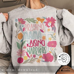 May include: A gray sweatshirt with a floral design and the text "Praying Mama Raising Warriors".