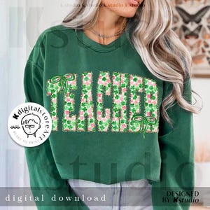 May include: Green sweatshirt with the word "TEACHER" in large, block letters. The letters are filled with a pattern of pink and green shamrocks and accented with green bows. The words "digital download" are at the bottom.