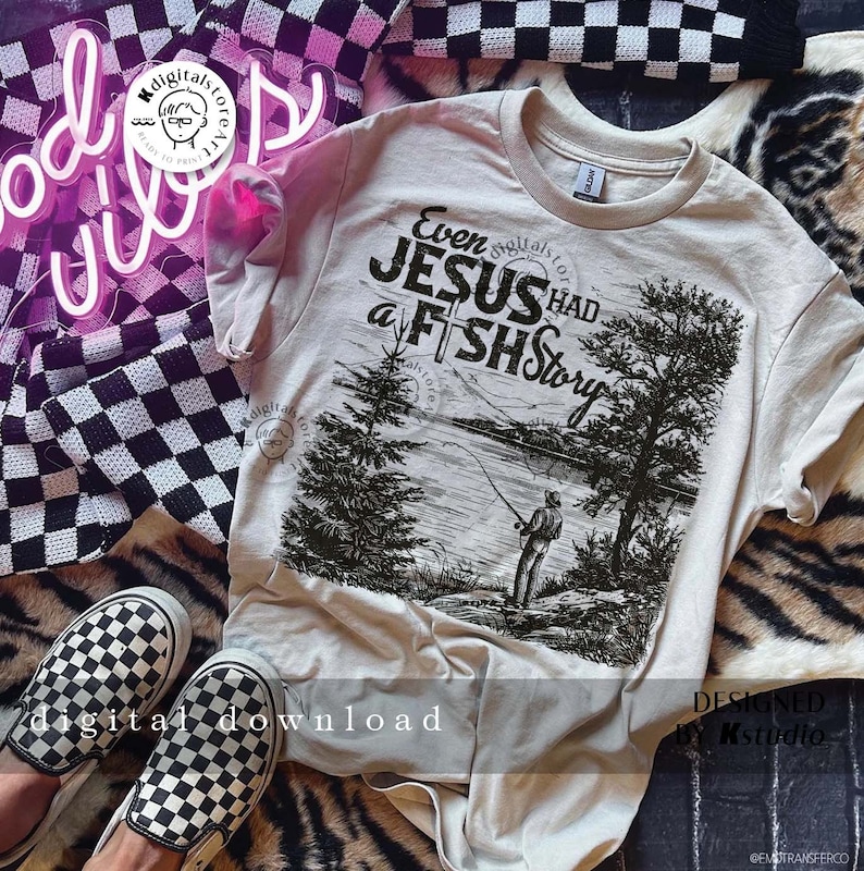 May include: A beige t-shirt with a black and white graphic print of a person fishing. The graphic includes the text "Even Jesus Had a Fish Story".