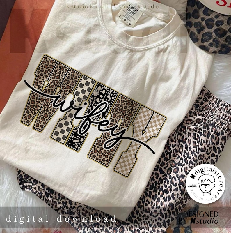 May include: Cream-coloured t-shirt with the word "Wifey" in a mix of leopard print, checkered, and dotted patterns. The shirt is paired with matching leopard print pyjama bottoms. The words "Digital Download" are at the bottom.