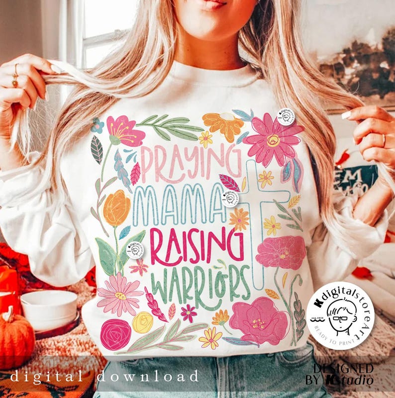 May include: White sweatshirt with a floral design and the text "Praying Mama Raising Warriors".
