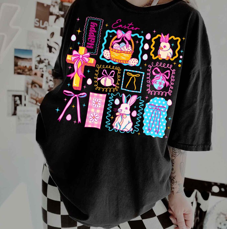 May include: Black t-shirt with a colorful Easter-themed graphic. The design includes a cross, Easter eggs, bunnies, bows, and the words "Happy" and "Easter". The graphic is framed with neon colors.