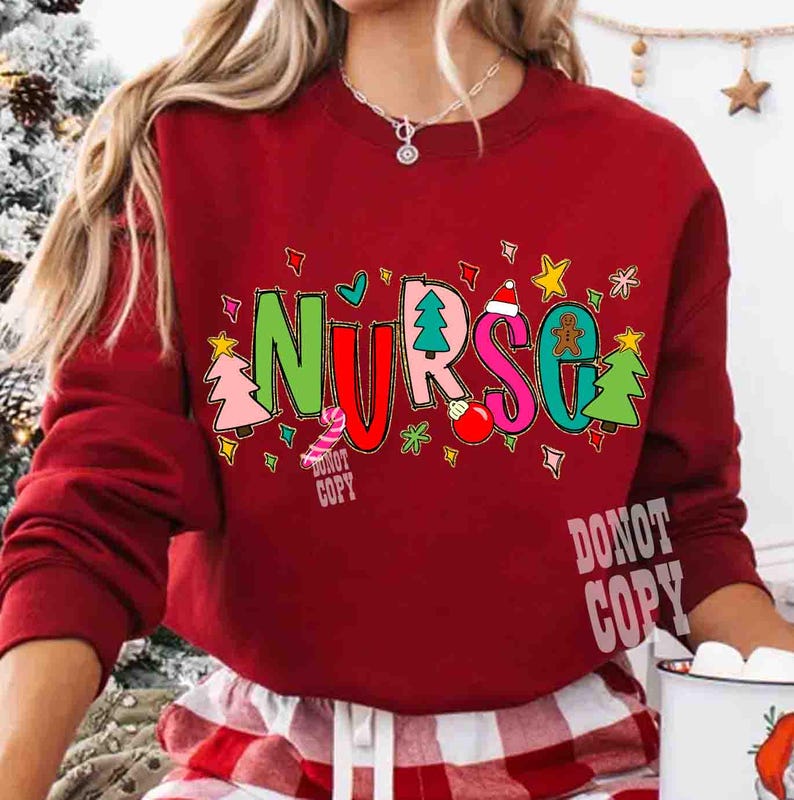 May include: A red sweatshirt with the word "NURSE" in colorful, festive lettering. The letters are decorated with Christmas-themed images like trees, ornaments, and gingerbread men. The text "DONOT COPY" is printed on the bottom.