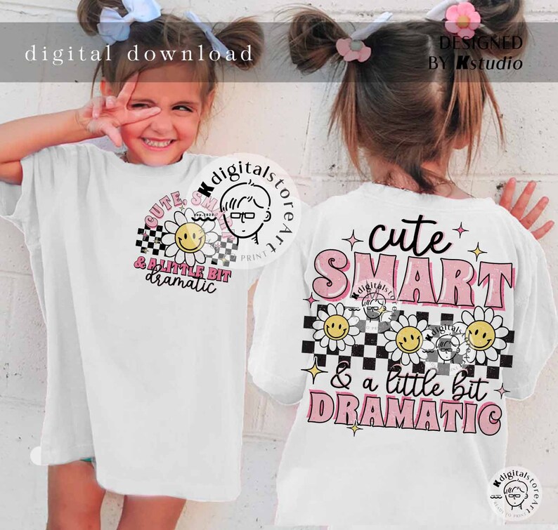 May include: White t-shirt with a pink and black design featuring the text "cute SMART & a little bit DRAMATIC". The design includes a checkered pattern, daisies with smiley faces, and pink stars.