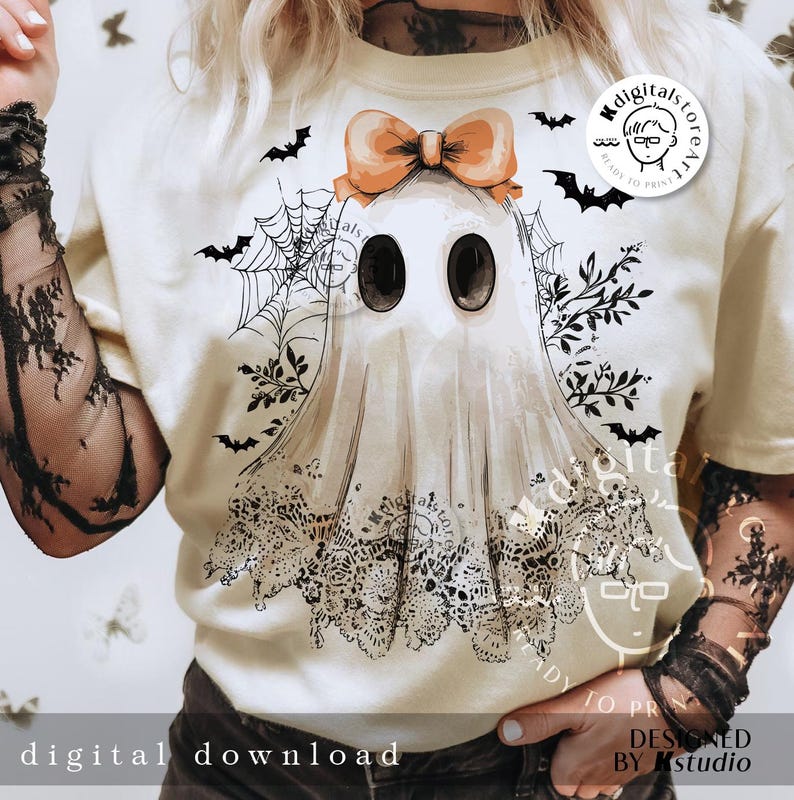 May include: Cream-colored t-shirt featuring a ghost illustration with a bow, lace details, and bat silhouettes. The ghost has large black eyes and a lace-trimmed bottom. The text "digital download" is at the bottom.